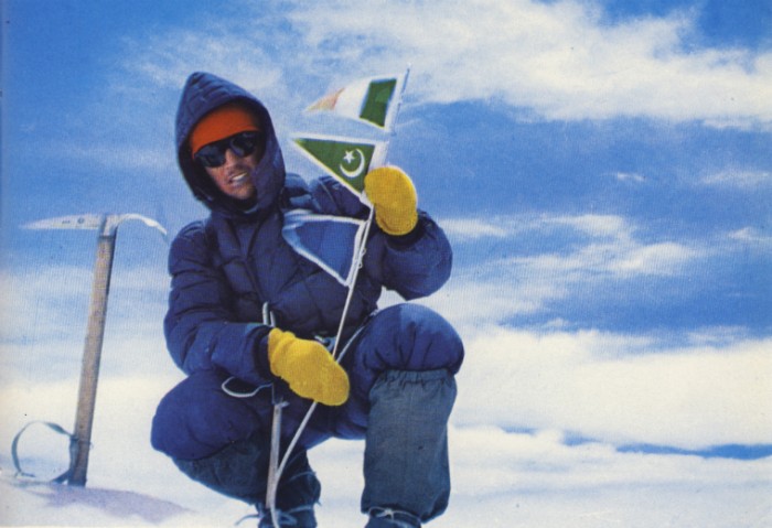 Walter Bonatti en la cumbre del Gasherbrum IV posando junto a su piolet con mango de madera.